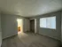 Spacious bedroom with plush carpet, large window, and en-suite bathroom, offering natural light and comfort.
