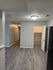 Bright, modern apartment interior with sleek hardwood floors, neutral walls, and ample hallway space perfect for stylish living.