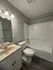 Modern bathroom featuring sleek fixtures, elegant lighting, and a spacious bathtub with a stylish countertop sink.