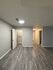 Modern apartment hallway featuring stylish wood flooring and bright, welcoming lighting.