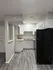 Modern kitchen with sleek dark flooring, bright cabinetry, and spacious countertops.