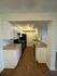 Inviting kitchen with modern black appliances, spacious countertops, and sleek wooden flooring.