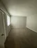 Bright, spacious bedroom with plush carpet and large window, offering a serene retreat in a modern apartment.