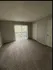 Bright, spacious bedroom with plush carpeting and large window doors opening to a serene balcony view.