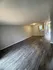 Elegant open space with sleek dark wood flooring, neutral gray walls, and ample natural light, ideal for a stylish living room setup.