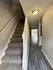 Inviting apartment entryway featuring plush carpeted stairs and sleek hardwood flooring leading to bright living space.