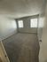 Bright bedroom with soft carpet and natural light from two windows, perfect for comfort and relaxation.