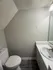 Modern bathroom featuring sleek gray walls, elegant white countertop with built-in sink, and contemporary toilet. Ideal for comfort and style in compact spaces.