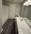 Sleek modern bathroom featuring a pristine white bathtub, elegant vanity, and stylish lighting fixtures.