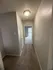 Inviting hallway with plush carpeting and modern lighting leading to a bright and spacious room.