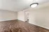 Inviting living room with elegant wood flooring, neutral walls, and bright overhead lighting, perfect for relaxation.