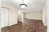 Elegant open-concept living space with rich wood flooring and abundant natural light, perfect for modern apartment living.