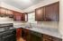 Modern kitchen featuring sleek granite countertops, rich wooden cabinetry, and contemporary appliances.