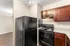 Modern kitchen with sleek black appliances, rich wood cabinetry, and granite countertops creating a warm, inviting atmosphere.