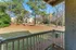 Charming apartment balcony overlooking a serene landscaped courtyard with lush greenery and mature trees.