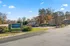 Inviting entrance to Avondale Reserve Apartment Homes surrounded by lush greenery and clear blue skies.