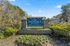 Inviting entrance sign for Avondale Reserve Apartment Homes surrounded by lush greenery and vibrant flowers on a sunny day.