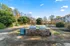 Charming outdoor living area featuring modern BBQ grills, lush greenery, and welcoming seating in a serene apartment complex courtyard.