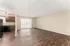 Spacious open-concept living area featuring elegant dark wood floors, ample natural light, and a sleek modern kitchen with granite countertops.