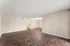 Spacious and bright living area with elegant dark wood flooring and soft neutral walls, perfect for modern living.