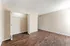 Spacious empty room with elegant wooden flooring, ample natural light, and a large open closet, ready for customization.