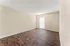 Bright and spacious room with elegant wood flooring, featuring a large window for natural light.