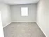 Bright and airy bedroom with plush carpeting and a large window, perfect for a cozy and inviting space.