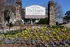 Inviting entrance to The Heights at Chamblee with vibrant flower beds and stone pillars, offering charming apartment homes.