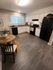 Inviting modern kitchen with sleek white cabinetry, cozy dining nook, and rustic wood flooring.