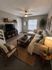 Inviting living room with modern beige sectional, stylish wooden furniture, and lush greenery creating a cozy, elegant atmosphere.
