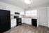 Modern kitchen with sleek black appliances, white cabinetry, and elegant granite countertops, offering a bright and functional cooking space.