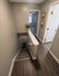 Charming hallway with elegant wood flooring, leading to a bright bedroom with stylish decor and modern finishes.