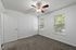 Bright and inviting bedroom with plush carpeting, ceiling fan, and double windows offering natural light.