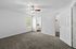 Bright and inviting bedroom with soft carpet, modern ceiling fan, and convenient access to a stylish bathroom and spacious walk-in closet.