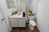 Bright, modern bathroom featuring sleek fixtures, elegant vanity, and stylish decor with fresh greenery.