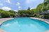 Inviting outdoor pool area surrounded by lush greenery at a serene apartment community.