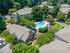 Charming apartment complex with inviting pool area surrounded by lush greenery and stylish buildings.