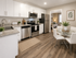 Contemporary kitchen with stainless steel appliances, elegant cabinetry, and a cozy dining area next to a stylish living room.