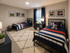 Inviting children's bedroom with twin beds adorned in vibrant navy and red striped bedding, sports-themed wall art, and cozy decor, offering a playful yet serene ambiance.