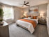 Cozy and modern bedroom featuring stylish decor with an inviting atmosphere, highlighted by elegant lighting and a large window for natural light.