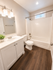Modern bathroom with elegant vanity, sleek fixtures, and inviting wood-style flooring.