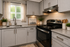Chic modern kitchen with sleek cabinetry, elegant countertops, and top-of-the-line stainless steel stove, bathed in natural light.