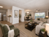 Inviting open-concept living room with sleek hardwood floors, comfortable seating, and natural light flowing through large windows, adjacent to a modern kitchen and elegant dining area.