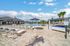Luxurious outdoor pool area with elegant lounge chairs, modern cabanas, and vibrant palm trees under a bright blue sky.