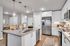 Modern kitchen with sleek countertops, stainless steel appliances, and elegant pendant lighting, perfect for contemporary living.