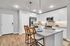 Contemporary kitchen with sleek white cabinetry, stainless steel appliances, and a stylish breakfast bar with elegant pendant lighting.