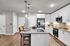 Modern kitchen with sleek white cabinets, granite countertops, and stainless steel appliances, featuring a stylish island with seating for two.