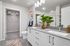 Elegant bathroom with modern double sink vanity, spacious walk-in closet, stylish decor, and natural plant accents.