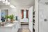 Modern bathroom with dual sinks, elegant gray countertops, and vibrant greenery, leading into a cozy bedroom with warm natural light.