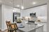 Modern kitchen with sleek white cabinetry, granite countertops, stainless steel appliances, and stylish pendant lighting.